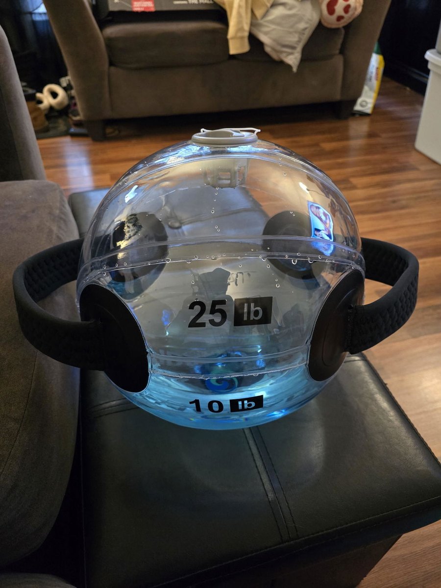 A part-filled sphere resting on a stool with its 25 lb and 10 lb markings visible.