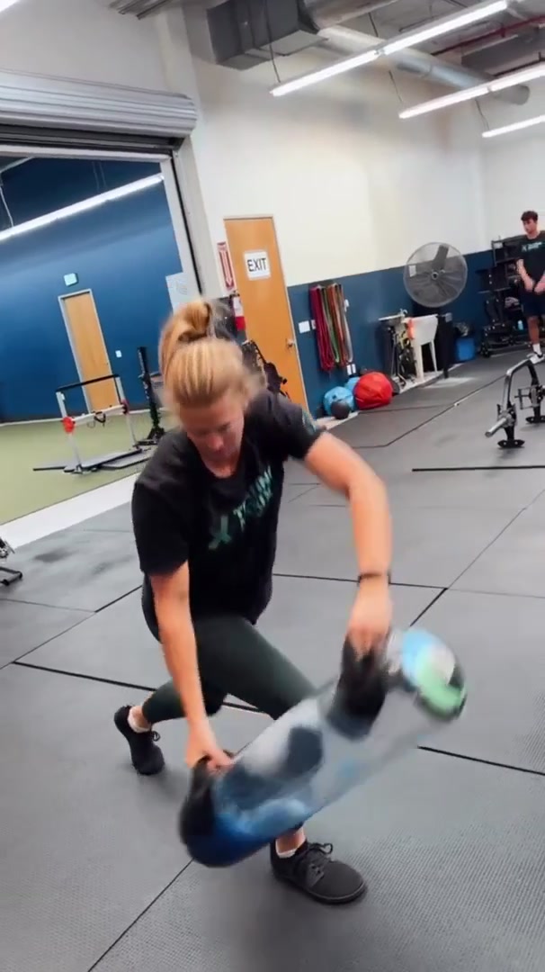An athlete transitioning through a lunge under a water-filled tube.