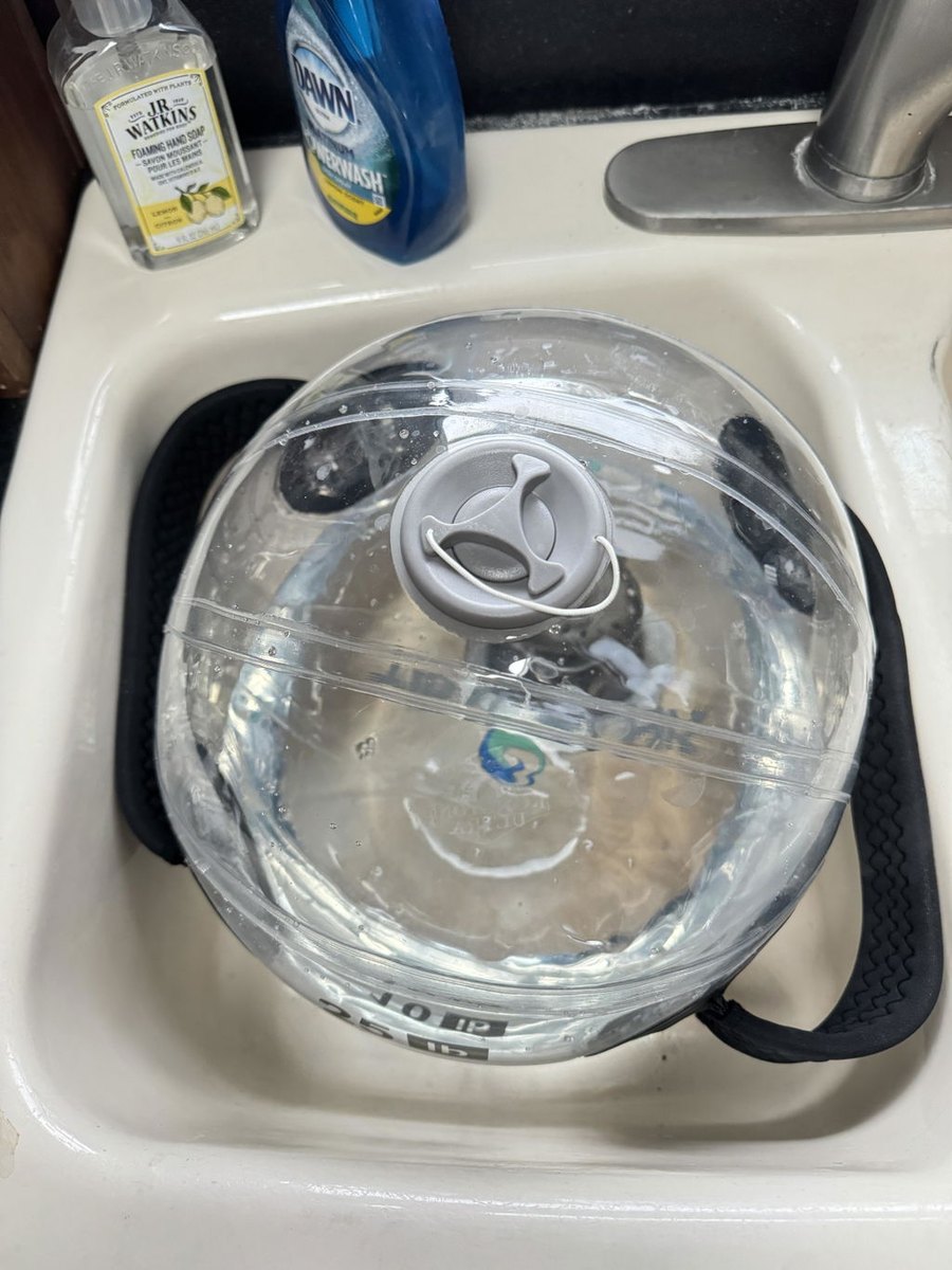 A water-filled sphere being filled in a bathroom sink.